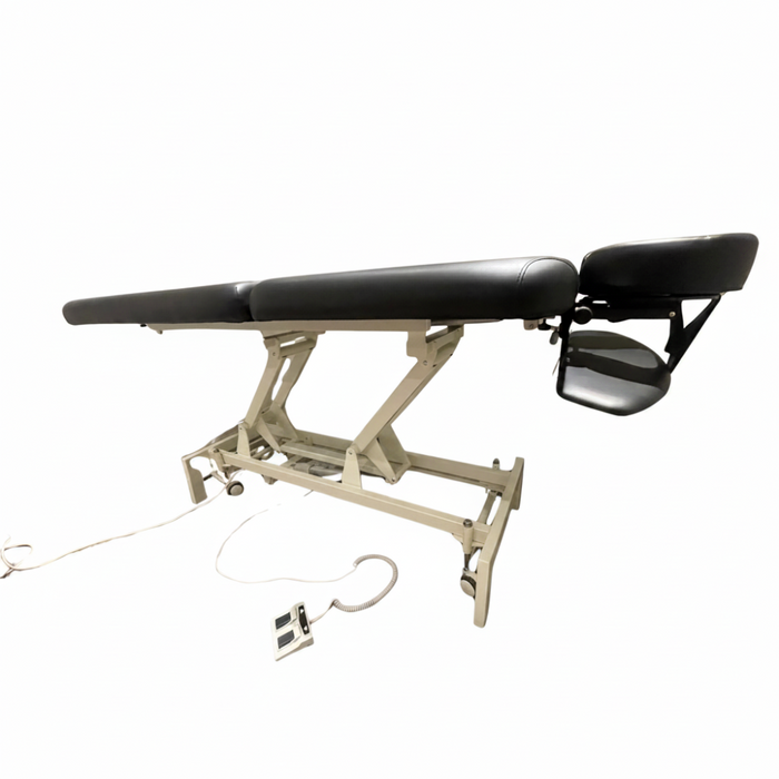 Side angled profile view of the black 2-section electric height control facial massage treatment table laid fully flat, showcasing its sturdy white steel lifting frame and sleek cushioning.