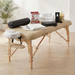 Massage table with accessories on a wooden floor in a room with plants