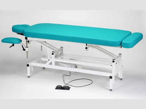 Standalone angled view of the blue Made in Canada A Lek Jupiter Electric Hi-Lo Massage Table, featuring a sturdy white metal frame, a foot pedal control for smooth height adjustment, and an integrated foot extension for professional clinic use.