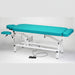 Standalone angled view of the blue Made in Canada A Lek Jupiter Electric Hi-Lo Massage Table, featuring a sturdy white metal frame, a foot pedal control for smooth height adjustment, and an integrated foot extension for professional clinic use.