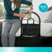 Bed assist rail model 5000 highlighting the prevents falls feature, woman using the black metal rail with attached storage pouch to get up from bed, from Therapy Supply