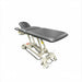 Black upholstered hi-lo elevation treatment table with adjustable headrest and face cradle, electric base, shown on a white background