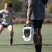 Action view of a physical therapist carrying the lightweight Chattanooga Intelect Transport 2 Ultrasound device by its top handle across an outdoor sports field, demonstrating its convenient mobility for athletic trainers.