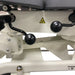 Close-up of black adjustment levers and hardware underneath a chiropractic treatment table