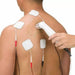 A lifestyle shot demonstrating the placement of electrotherapy pads on a patient's back for targeted pain management with the ComboCare device.