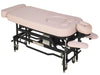 Angled view of the MT Electric Hi-Lo Massage Table with the prenatal option, featuring a sturdy black metal frame, pink upholstery, and specialized cutouts for belly and breast comfort during professional therapy.