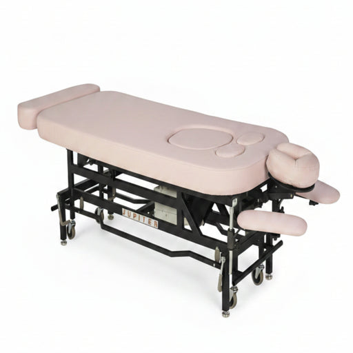 Angled view of the MT Electric Hi-Lo Massage Table with the prenatal option, featuring a sturdy black metal frame, pink upholstery, and specialized cutouts for belly and breast comfort during professional therapy.