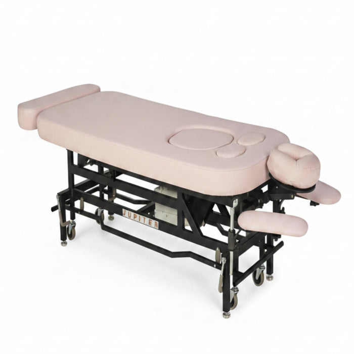 Angled view of the MT Electric Hi-Lo Massage Table with the prenatal option, featuring a sturdy black metal frame, pink upholstery, and specialized cutouts for belly and breast comfort during professional therapy.