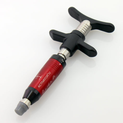 Standalone angled view of the Activator IV manual adjusting instrument, featuring a red barrel, a preload tip, and ergonomic black handles designed for verified healthcare professionals treating tender areas of the body.