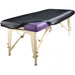Full angled view of a portable massage table completely protected by the sleek, black Universal Fitted PU Vinyl Cover, ready for clinical or spa use.