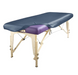 Angled view of a portable massage table fitted with the PU Vinyl Protection Cover in a dark blue colorway, demonstrating versatility for different treatment room aesthetics.